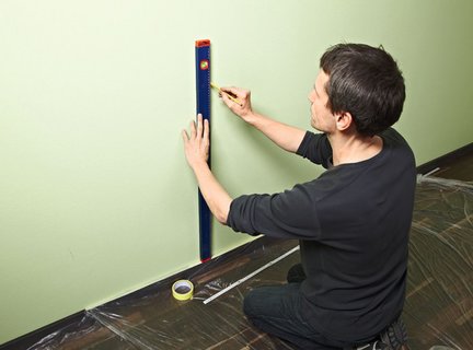 1. Za pomocą poziomnicy i ołówka wyznaczamy powierzchnię przeznaczoną do oklejenia tapetami, a następnie oklejamy jej krawędzie taśmą malarską.